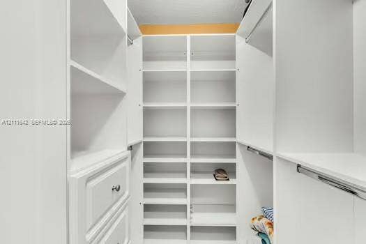 12801 SW 248th Terrace, Homestead, FL 33032 Custom white cabinetry featuring floor-to-ceiling shelving, built-in drawer storage, and integrated hanging rods