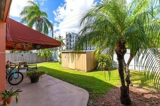 12801 SW 248th Terrace, Homestead, FL 33032 Covered concrete patio, fenced backyard, and mature palm trees