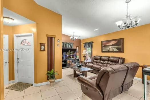 12801 SW 248th Terrace, Homestead, FL 33032 Entryway featuring high ceilings, light-colored tile flooring, decorative chandeliers, and a white six-panel door with arched glass inlay