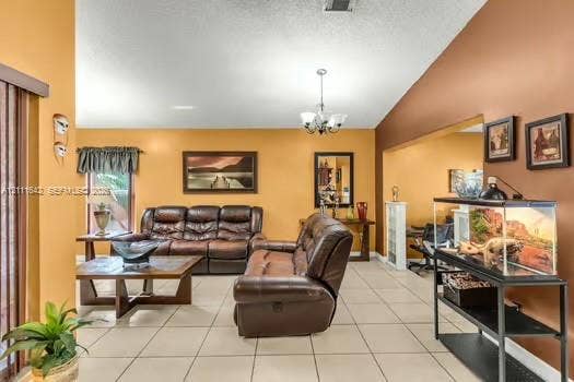 12801 SW 248th Terrace, Homestead, FL 33032 Living area featuring vaulted ceilings, light-toned ceramic tile flooring, a multi-arm chandelier, and a wide interior wall cutout