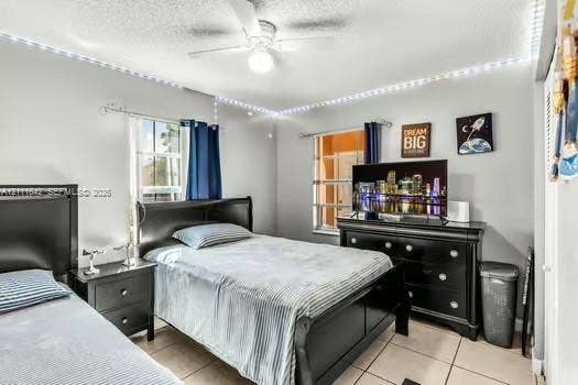 12801 SW 248th Terrace, Homestead, FL 33032 Neutral-toned room featuring neutral ceramic tile flooring, dual windows with curtain rods, and a ceiling-mounted light fixture with a central fan