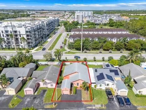 12801 SW 248th Terrace, Homestead, FL 33032 Single-story residence featuring a paved driveway, attached garage, and mature palm trees