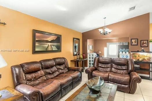 12801 SW 248th Terrace, Homestead, FL 33032 Vaulted ceiling with a multi-arm chandelier, neutral tile flooring, and glass block accent wall