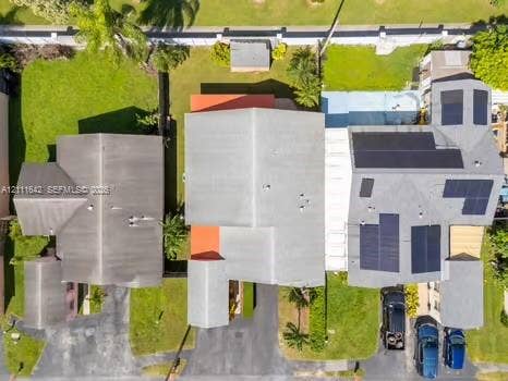12801 SW 248th Terrace, Homestead, FL 33032 Aerial perspective featuring a multi-structure property with solar panel arrays, shingle roofing, paved driveways, and landscaped lawn areas
