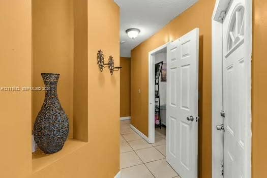 12801 SW 248th Terrace, Homestead, FL 33032 Entryway featuring recessed wall niche, ceramic tile flooring, six-panel interior door, and flush-mount ceiling lighting