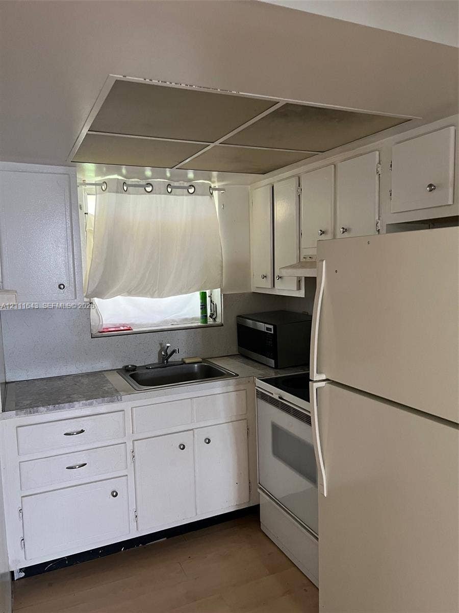 4841 SW 45th Avenue, #1, Hollywood, Hollywood, FL 33314 Kitchen featuring white cabinetry, stone-finish countertops, an undermount stainless steel sink, and wood-finish flooring