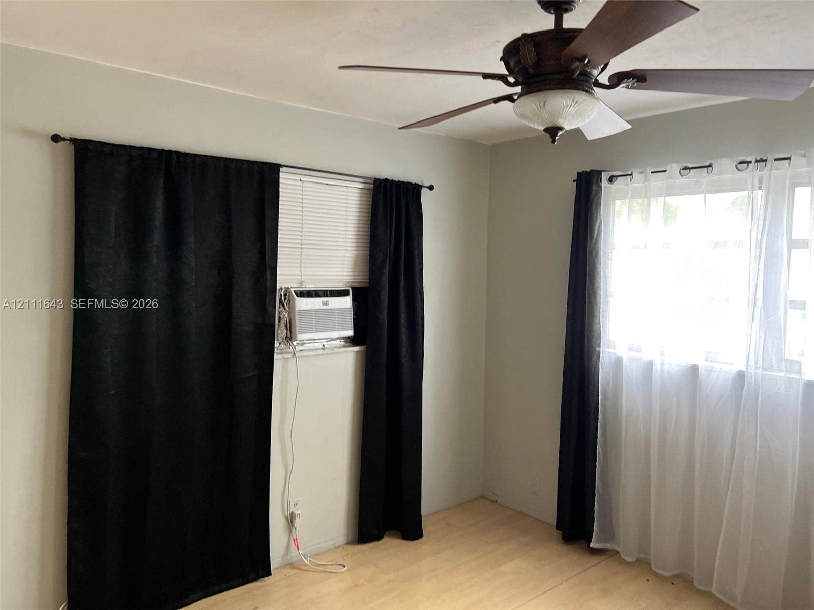 4841 SW 45th Avenue, #1, Hollywood, Hollywood, FL 33314 Light-toned wood-finish flooring, multi-pane windows, and a ceiling fan with integrated light fixture