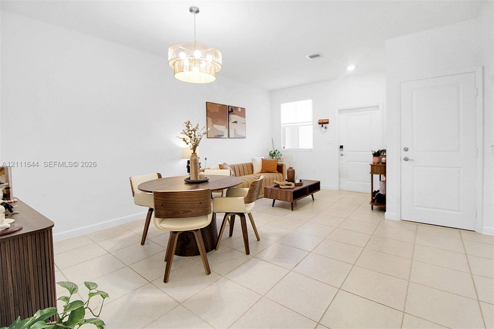 2873 SE 24th Avenue, Homestead, FL 33035 Large-format tile flooring, drum-style chandelier with metallic finish, crisp white wall palette, and six-panel interior door