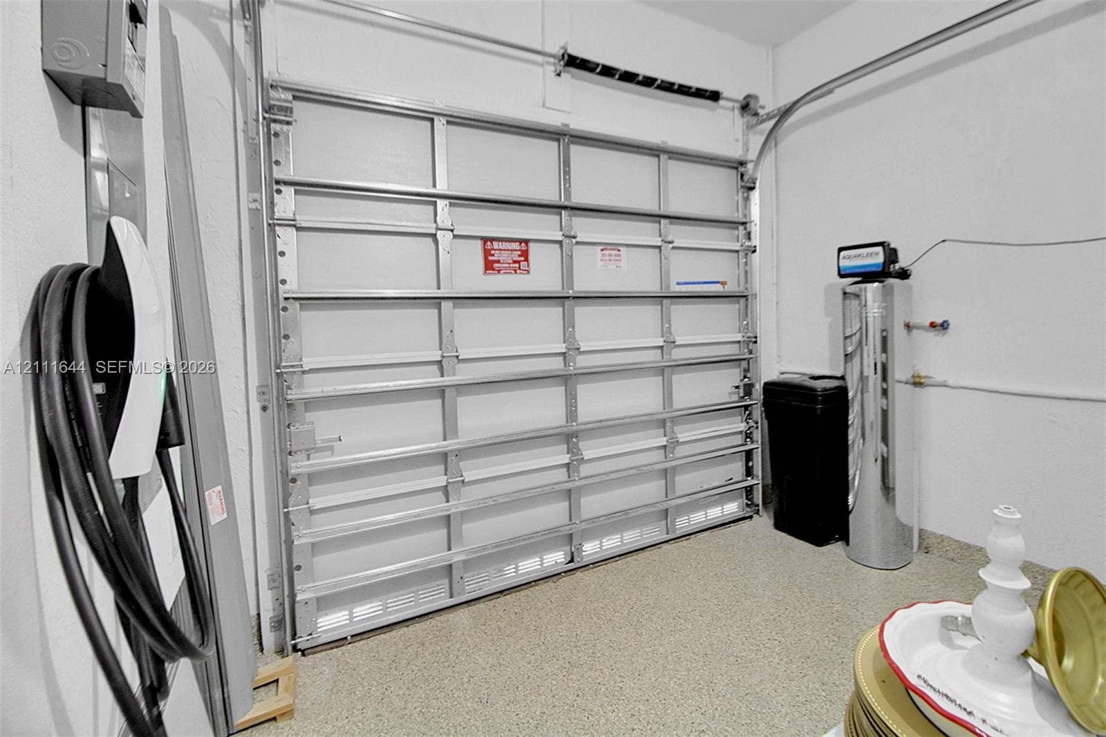 2873 SE 24th Avenue, Homestead, FL 33035 Attached electric vehicle charging station, overhead metal garage door, epoxy-coated flooring, and installed water filtration system