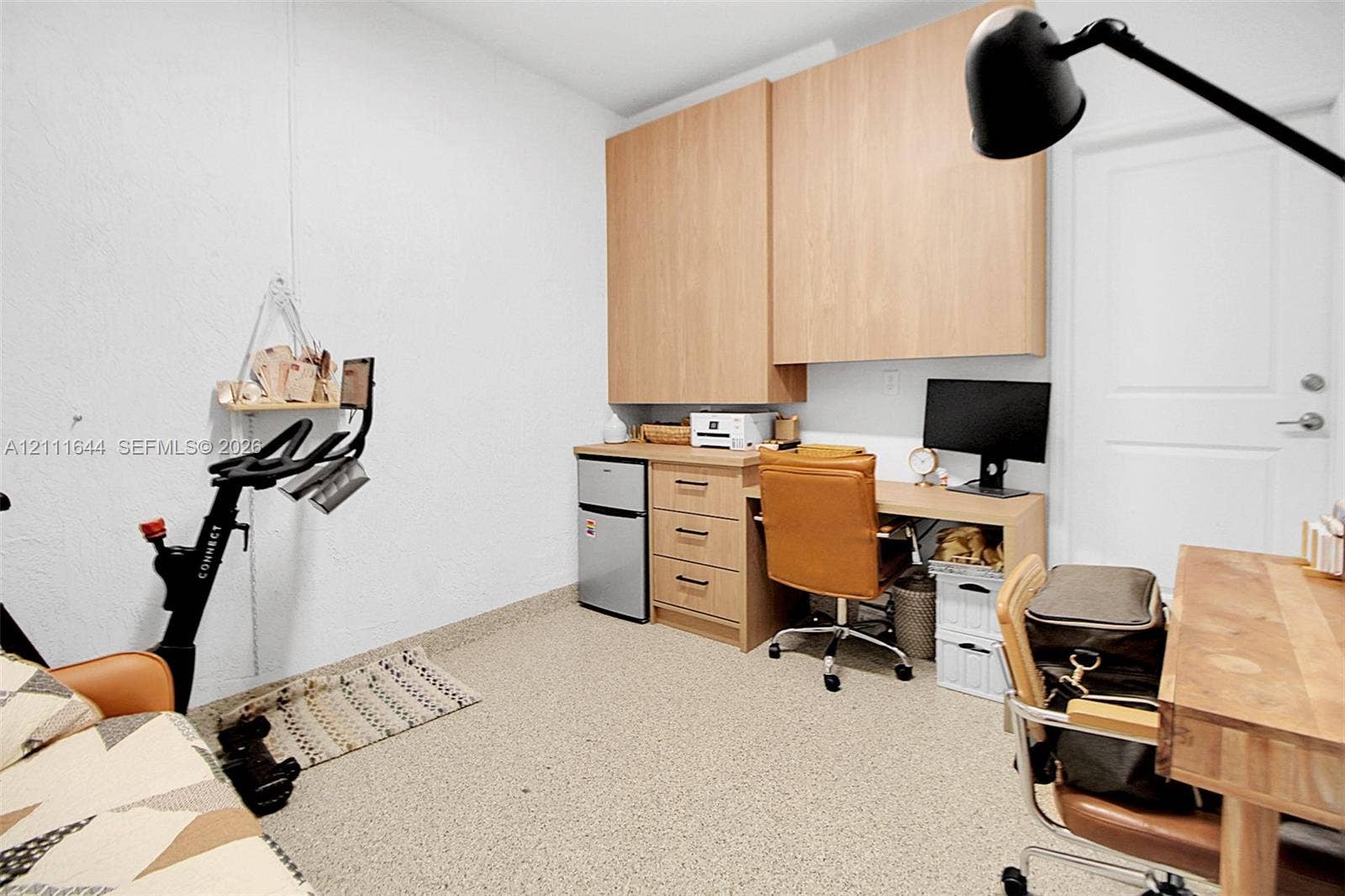 2873 SE 24th Avenue, Homestead, FL 33035 Built-in light-wood cabinetry with upper storage, integrated desk workspace with three drawers, and textured flooring