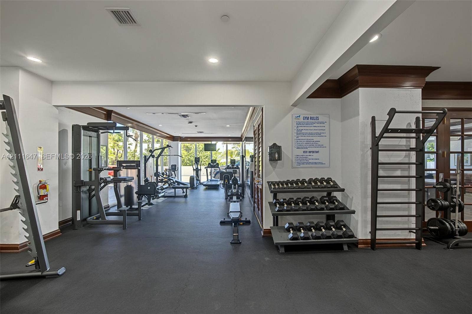 8925 Collins Avenue, #4J, Surfside, FL 33154 Fitness center featuring dark rubber flooring, recessed ceiling lighting, wall-mounted fitness equipment, and crown molding