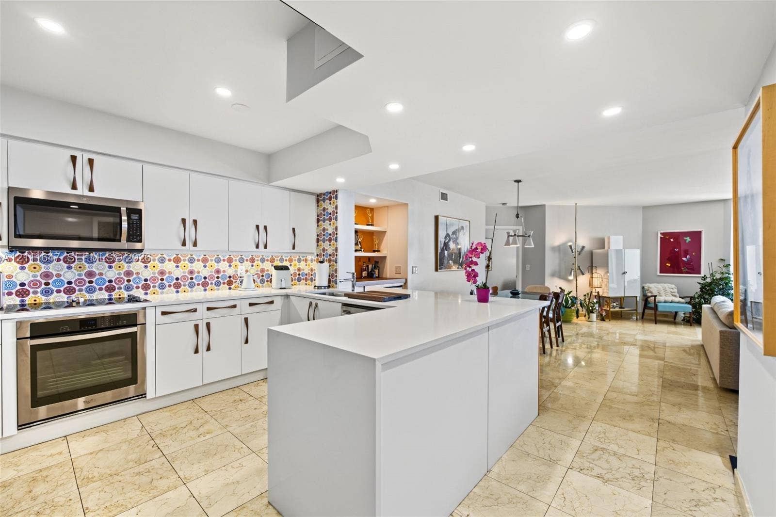8925 Collins Avenue, #4J, Surfside, FL 33154 Kitchen featuring white cabinetry, stainless steel appliances, quartz countertops, a patterned tile backsplash, and tile flooring