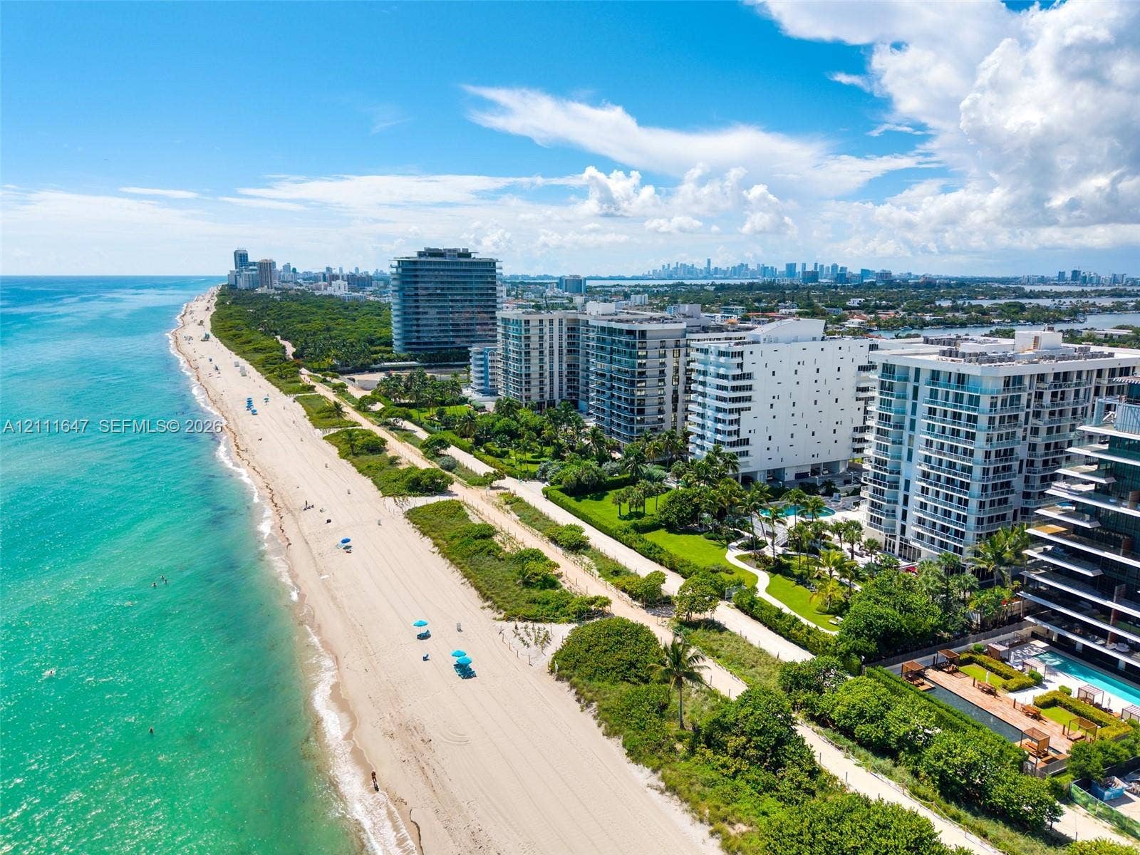 8925 Collins Avenue, #4J, Surfside, FL 33154 Coastal aerial perspective featuring direct oceanfront access, pristine sandy shoreline, and proximity to expansive waterfront high-rise development