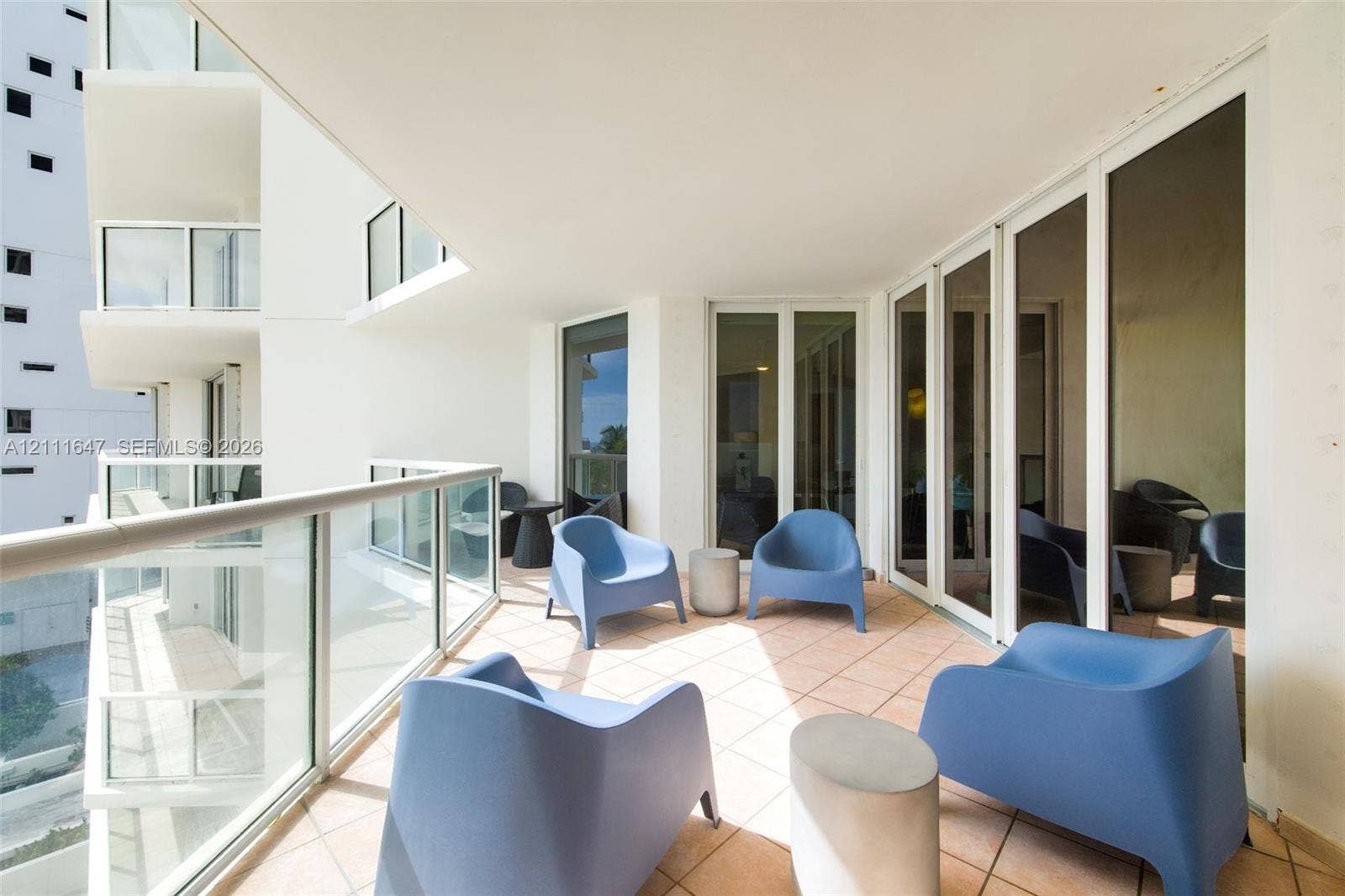 8925 Collins Avenue, #4J, Surfside, FL 33154 Covered balcony featuring tile flooring, glass panel railing, and multi-panel glass sliding doors