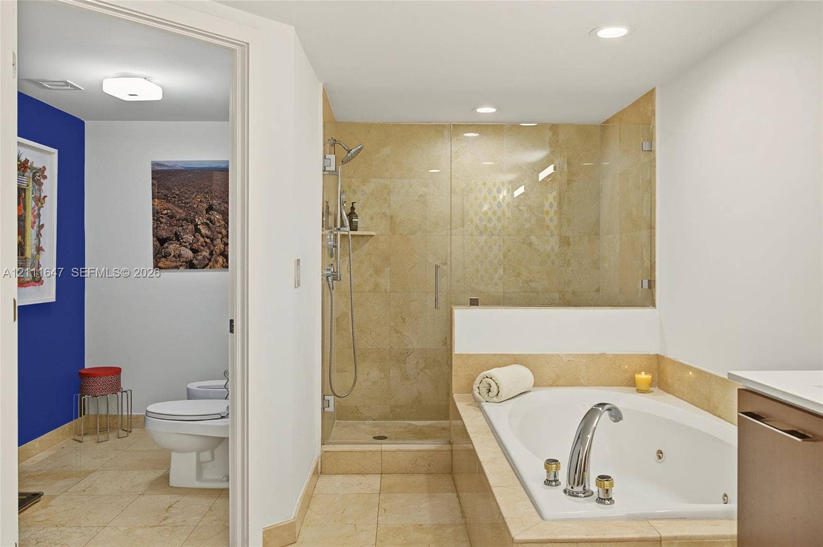 8925 Collins Avenue, #4J, Surfside, FL 33154 Walk-in shower with natural stone tiling and glass enclosure, integrated jetted soaking tub with stone surround, and tile flooring