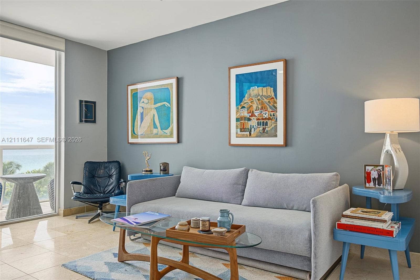 8925 Collins Avenue, #4J, Surfside, FL 33154 Polished stone flooring, expansive glass door, and neutral-toned wall finish