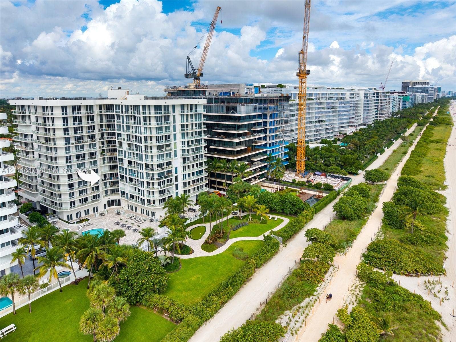 8925 Collins Avenue, #4J, Surfside, FL 33154 Multi-story residential complex featuring private pool, expansive manicured grounds, mature palm trees, and direct sand-beach access