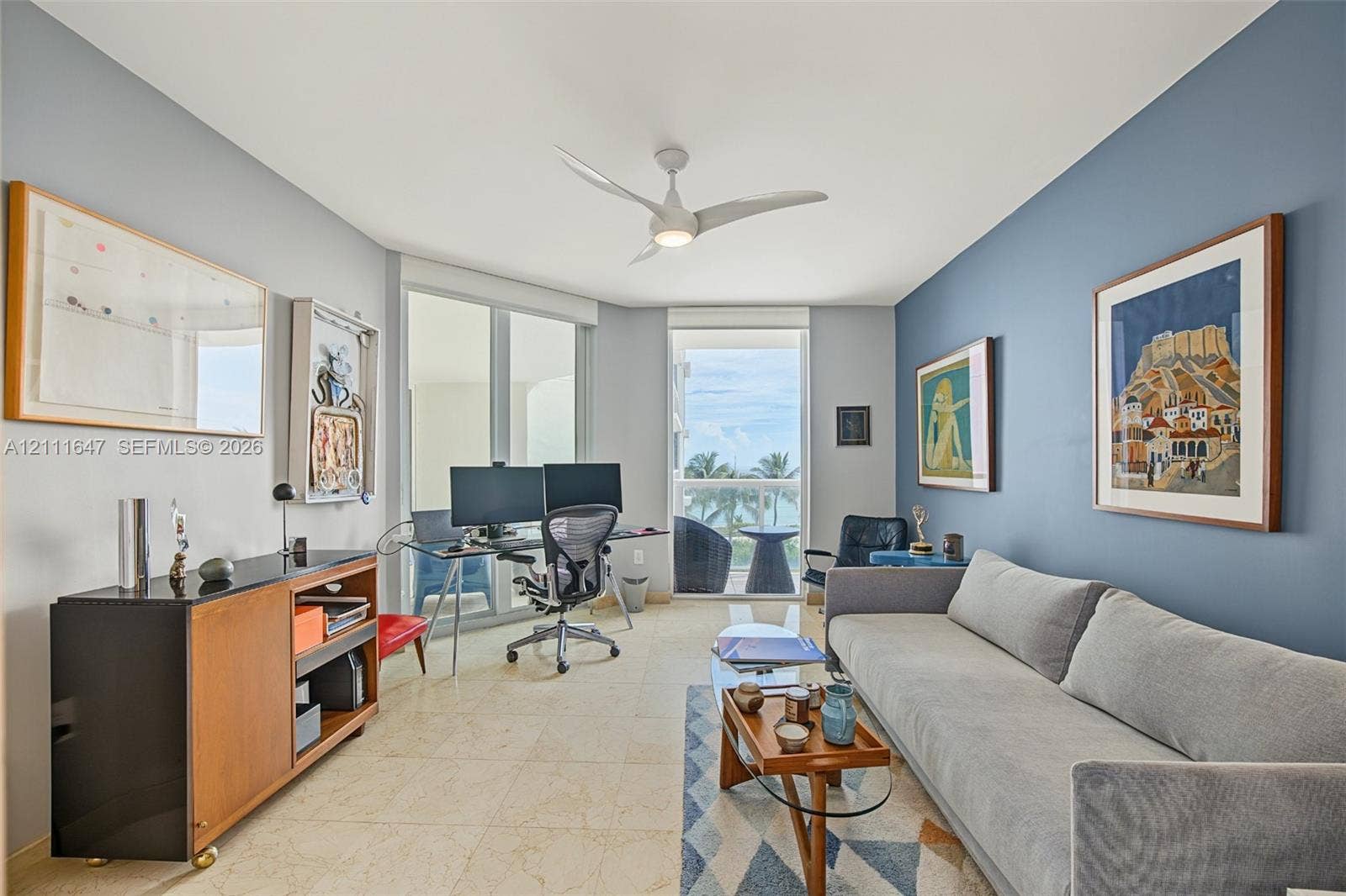 8925 Collins Avenue, #4J, Surfside, FL 33154 Neutral-toned tile flooring, three-blade ceiling fan with integrated lighting, dual glass-paneled entryways, and floor-to-ceiling glass wall panels