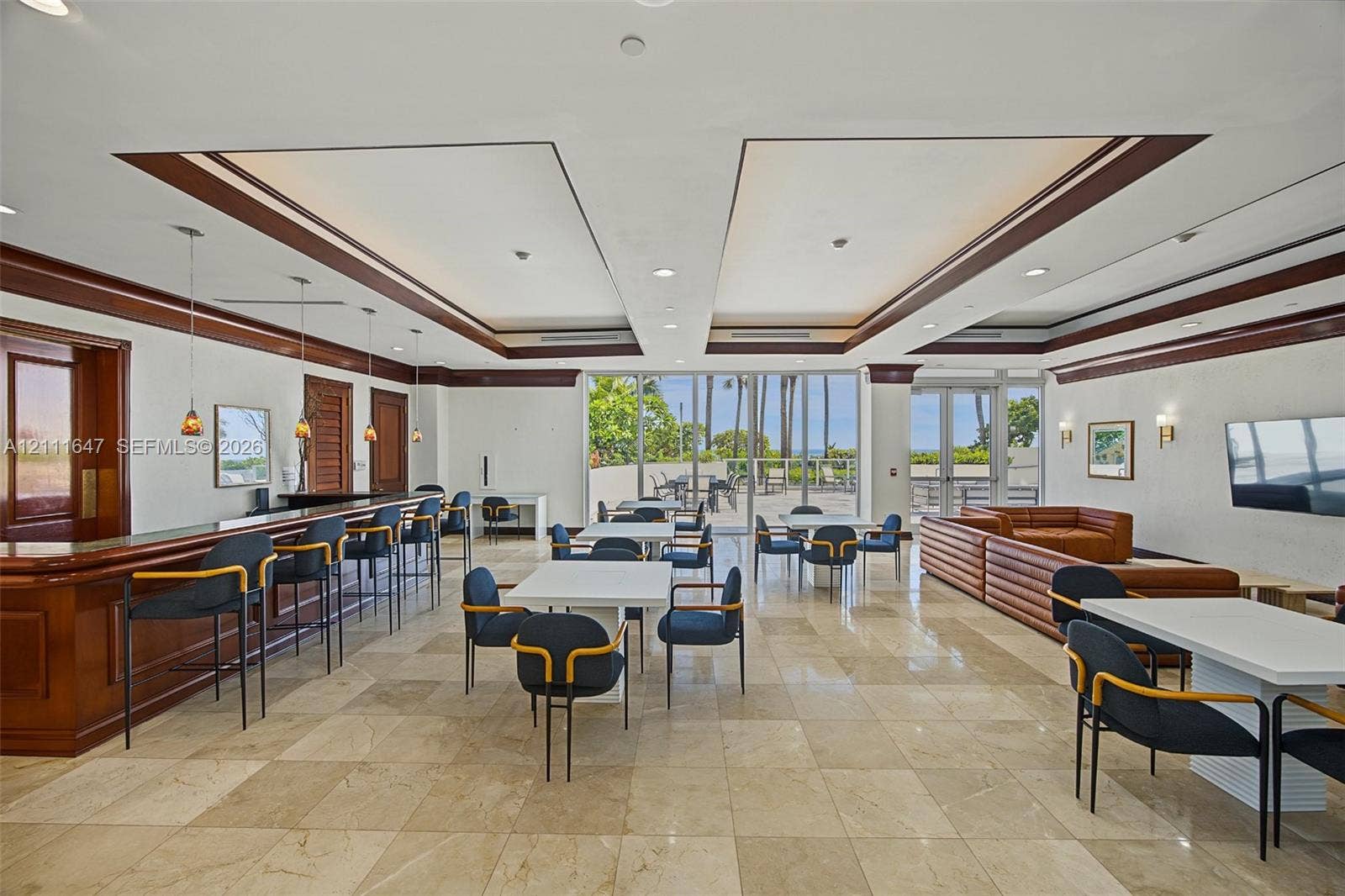 8925 Collins Avenue, #4J, Surfside, FL 33154 Open-concept common area featuring stone tile flooring, a built-in bar with wood cabinetry, recessed tray ceilin