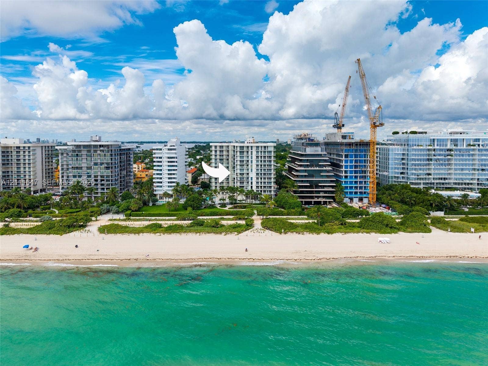 8925 Collins Avenue, #4J, Surfside, FL 33154 High-rise building situated on an oceanfront lot featuring direct beach access, coastal scenery, and mature landscaping