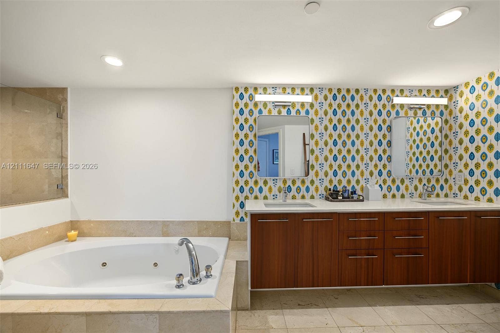 8925 Collins Avenue, #4J, Surfside, FL 33154 Dual-sink vanity with wood-finish cabinetry, quartz countertops, jetted soaking tub, stone tile surround, and recessed lighting