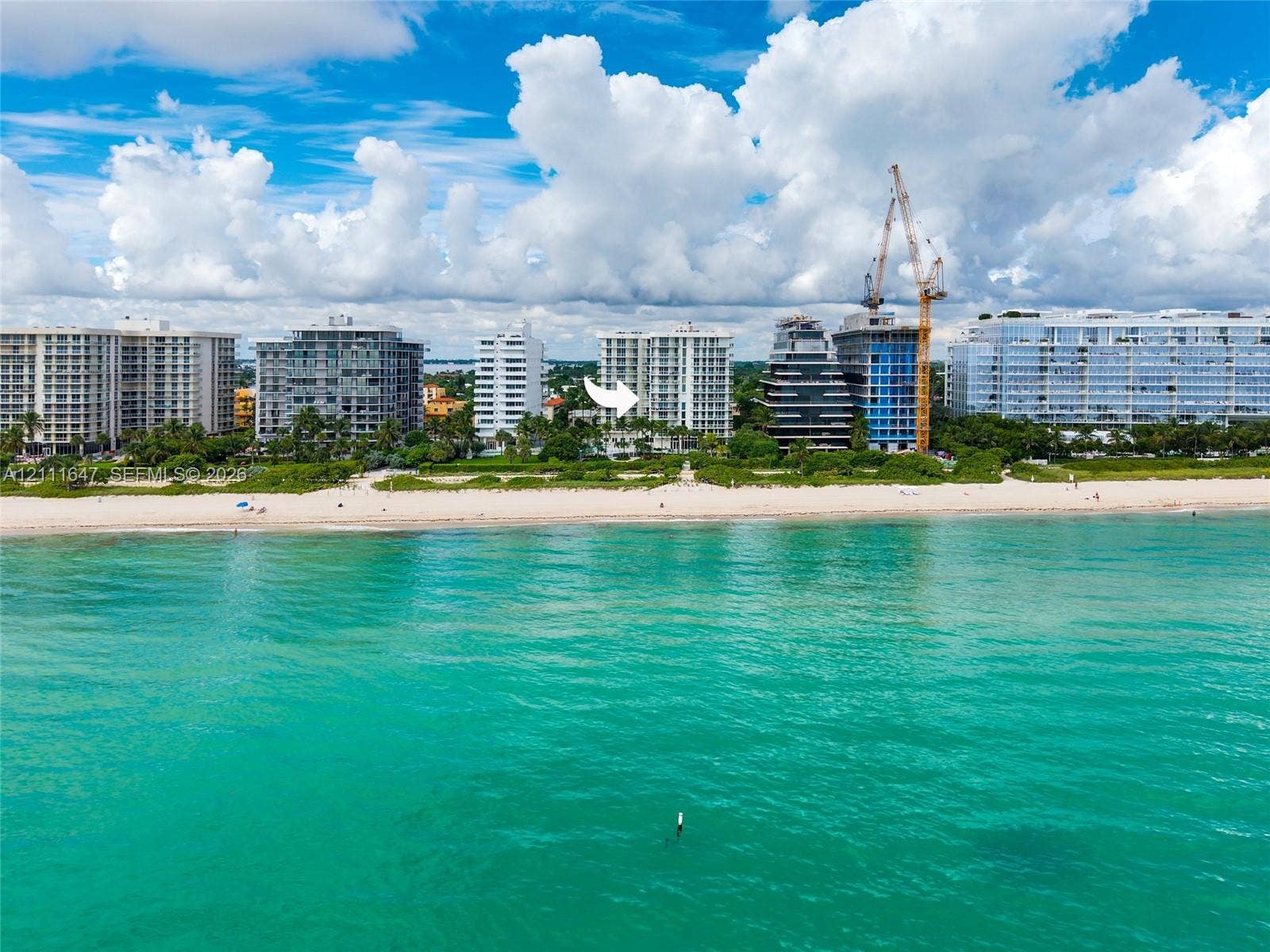 8925 Collins Avenue, #4J, Surfside, FL 33154 Multi-story high-rise building situated on a direct oceanfront lot featuring sandy beach access and surrounding tropical landscaping