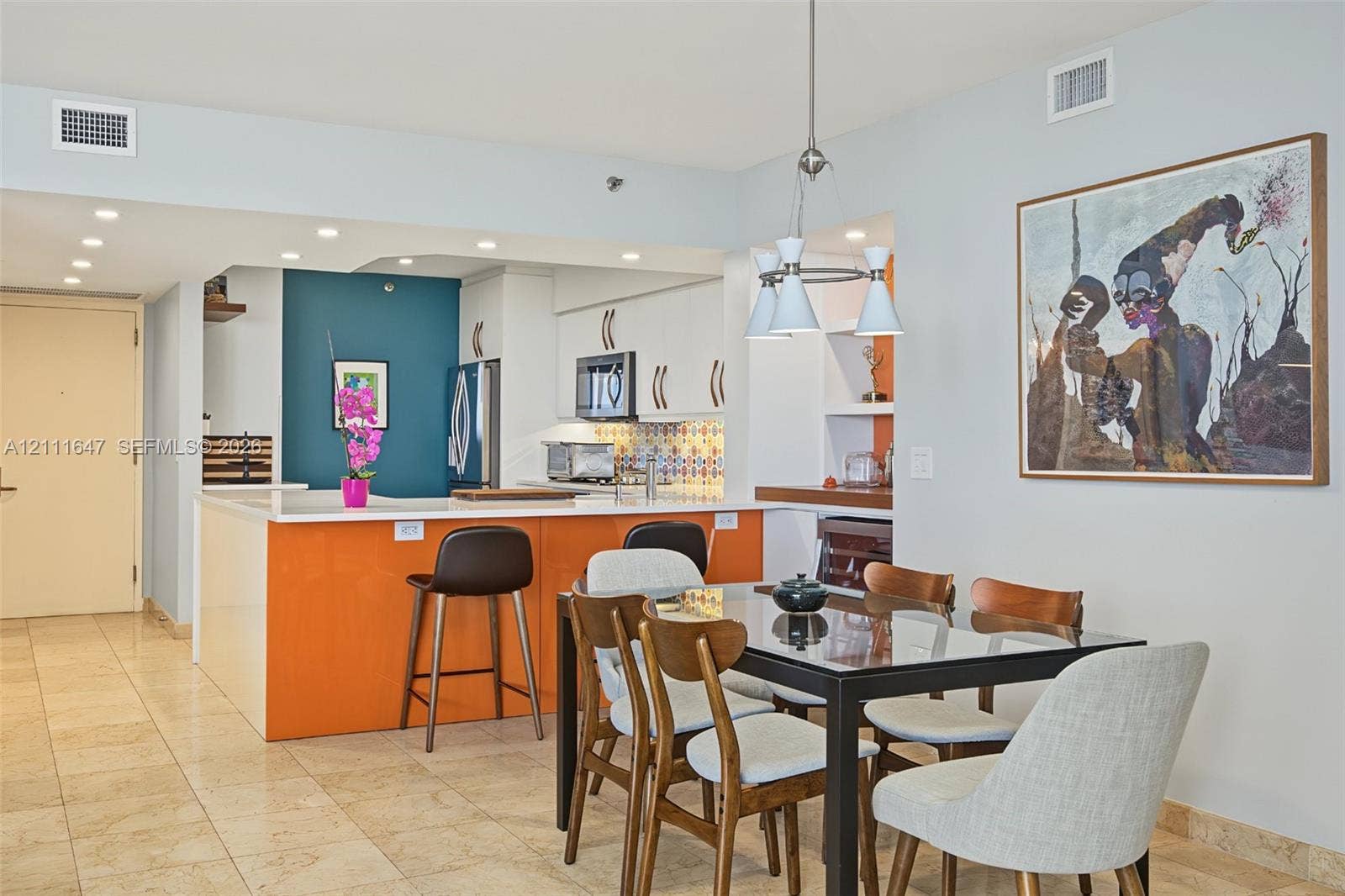 8925 Collins Avenue, #4J, Surfside, FL 33154 Kitchen featuring white cabinetry, island with integrated seating, patterned tile backsplash, recessed lighting, and tile flooring