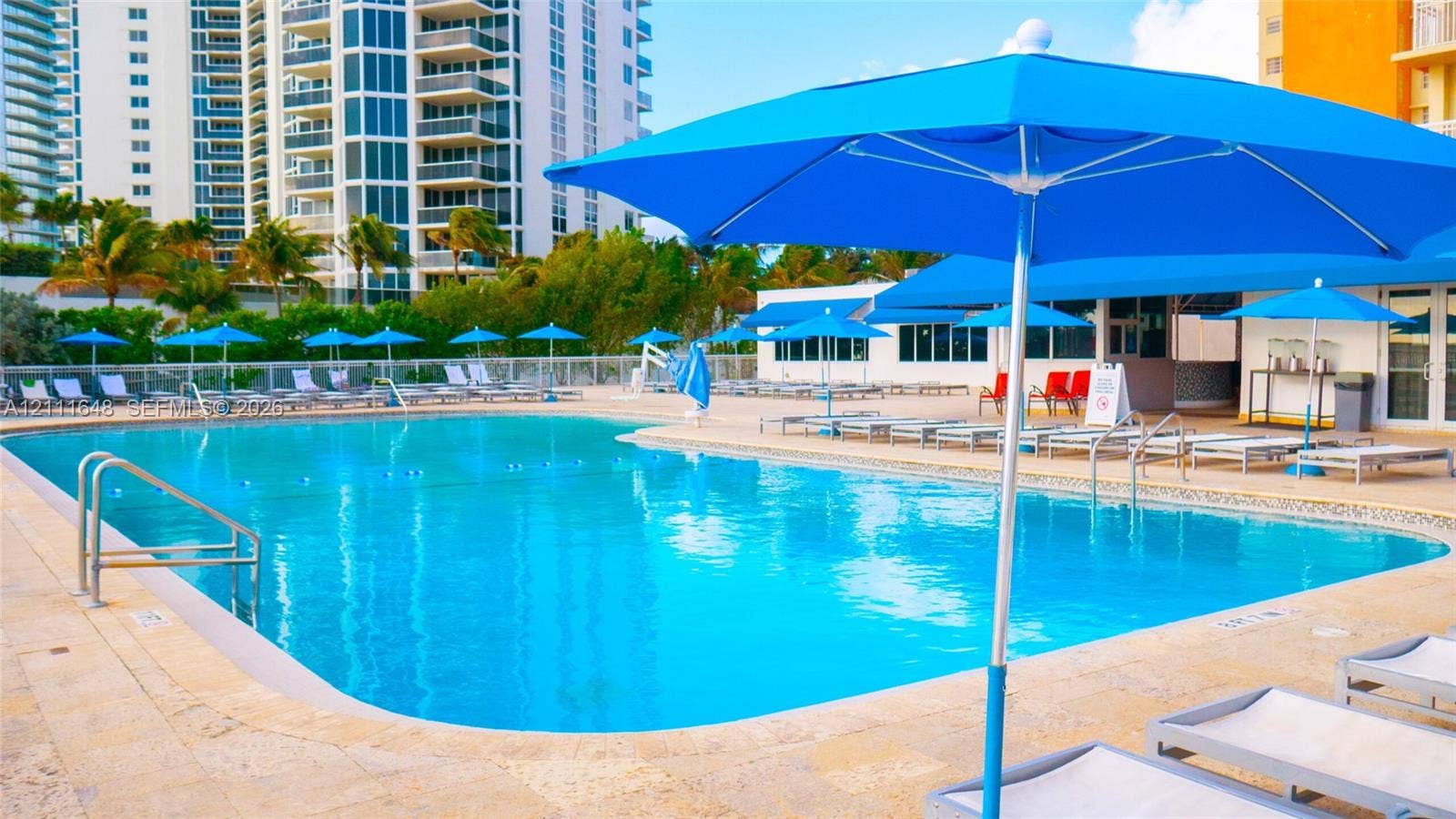 19201 Collins Avenue, #518, Sunny Isles Beach, FL 33160 Swimming pool with a stone deck, metal handrails, and a perimeter fence