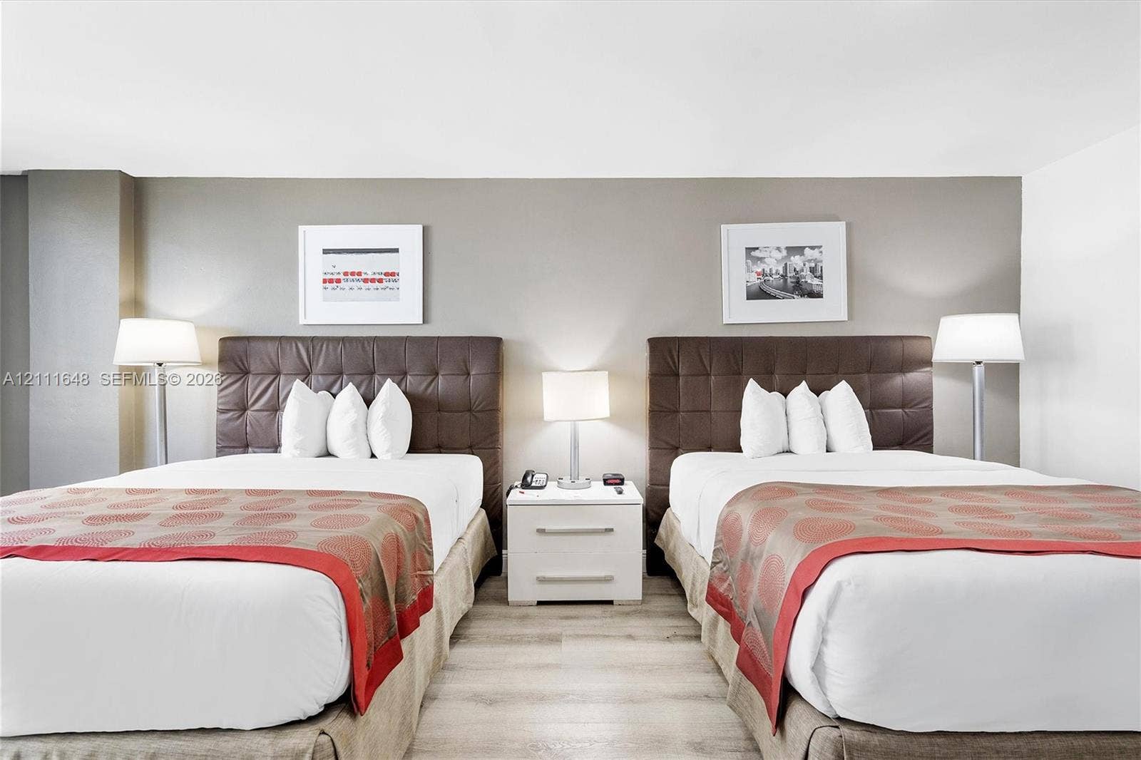 19201 Collins Avenue, #518, Sunny Isles Beach, FL 33160 Light-toned wood-finish flooring and a central white two-drawer nightstand with a metallic finish hardware
