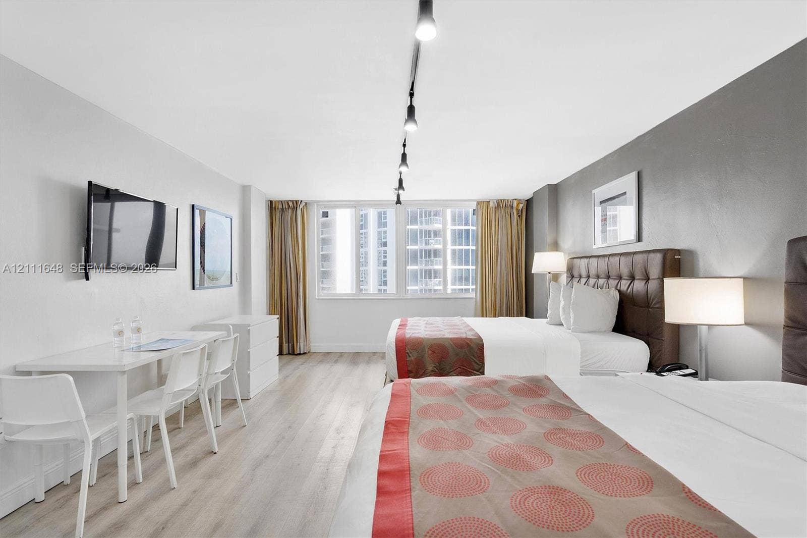 19201 Collins Avenue, #518, Sunny Isles Beach, FL 33160 Large windows with natural lighting, wood-finish flooring, track lighting, and a neutral color palette