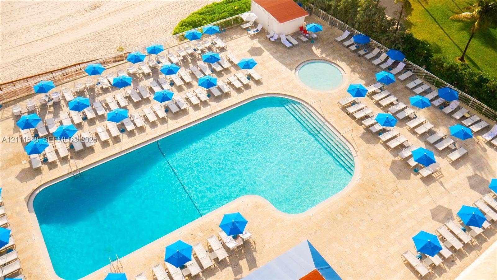 19201 Collins Avenue, #518, Sunny Isles Beach, FL 33160 Expansive outdoor pool area featuring stone-paver decking, a secondary circular wading pool, direct beach access, and surrounding landscaped grounds