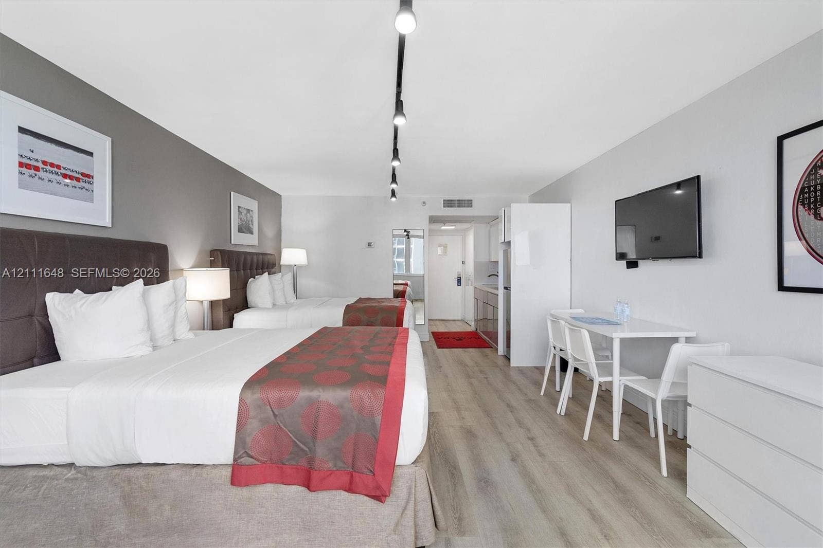 19201 Collins Avenue, #518, Sunny Isles Beach, FL 33160 Wood-finish flooring, track lighting, and integrated kitchenette cabinetry