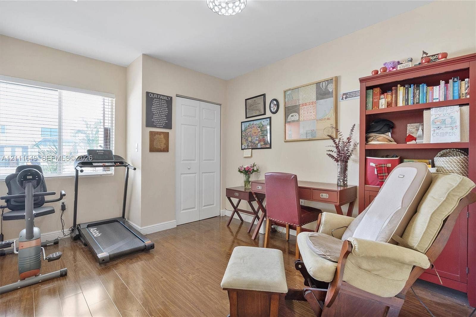 Wood-finish flooring, white double-panel closet doors, flush-mount ceiling lighting, and a large window with natural light
