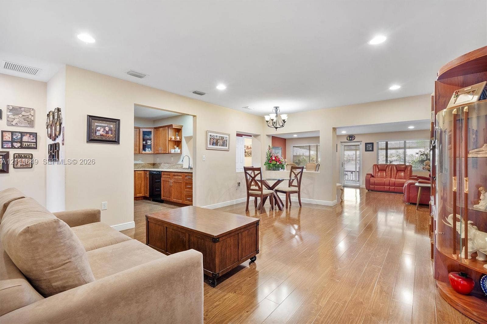 Wood-finish flooring, recessed lighting, chandelier, and built-in wood cabinetry