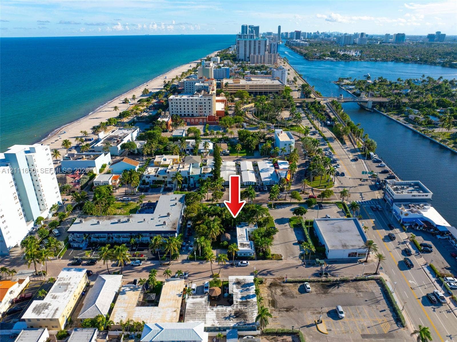 Aerial perspective showcasing a coastal parcel situated between the Atlantic Ocean and the Intracoastal Waterway, featuring mature palms and proximity to local thoroughfares
