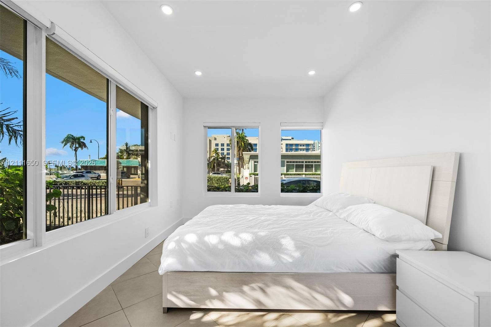 Bright interior space featuring floor-to-ceiling windows, recessed lighting, and large-format tile flooring