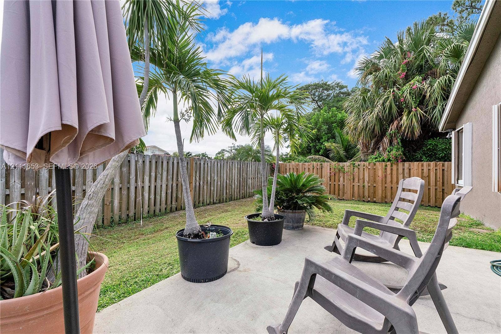 1042 NE 38th Street, Oakland Park, FL 33334 Rear concrete patio featuring a fenced yard