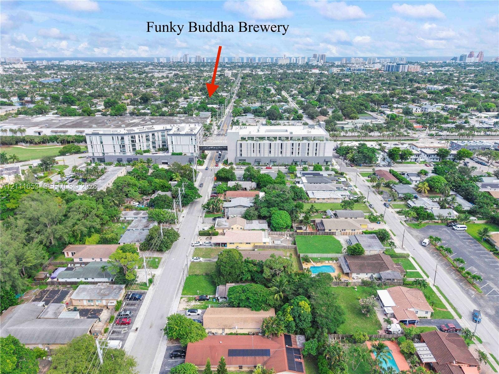 1042 NE 38th Street, Oakland Park, FL 33334 Just a stone's throw from Oakland Park's Funky Buddha Brewery, aerial perspective of the urban neighborhood featuring established tree canopy, paved roadway infrastructure, residential properties