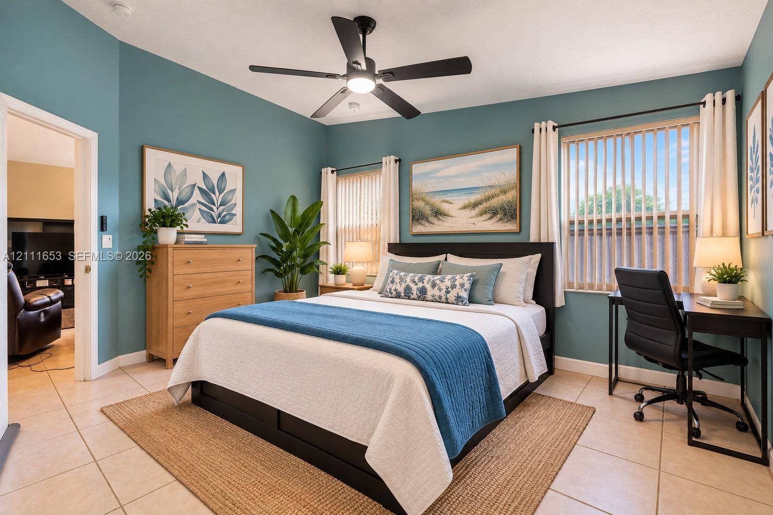1042 NE 38th Street, Oakland Park, FL 33334 Primary Bedroom featuring tile flooring, dual windows with vertical blinds, and a matte black ceiling fan with integrated lighting