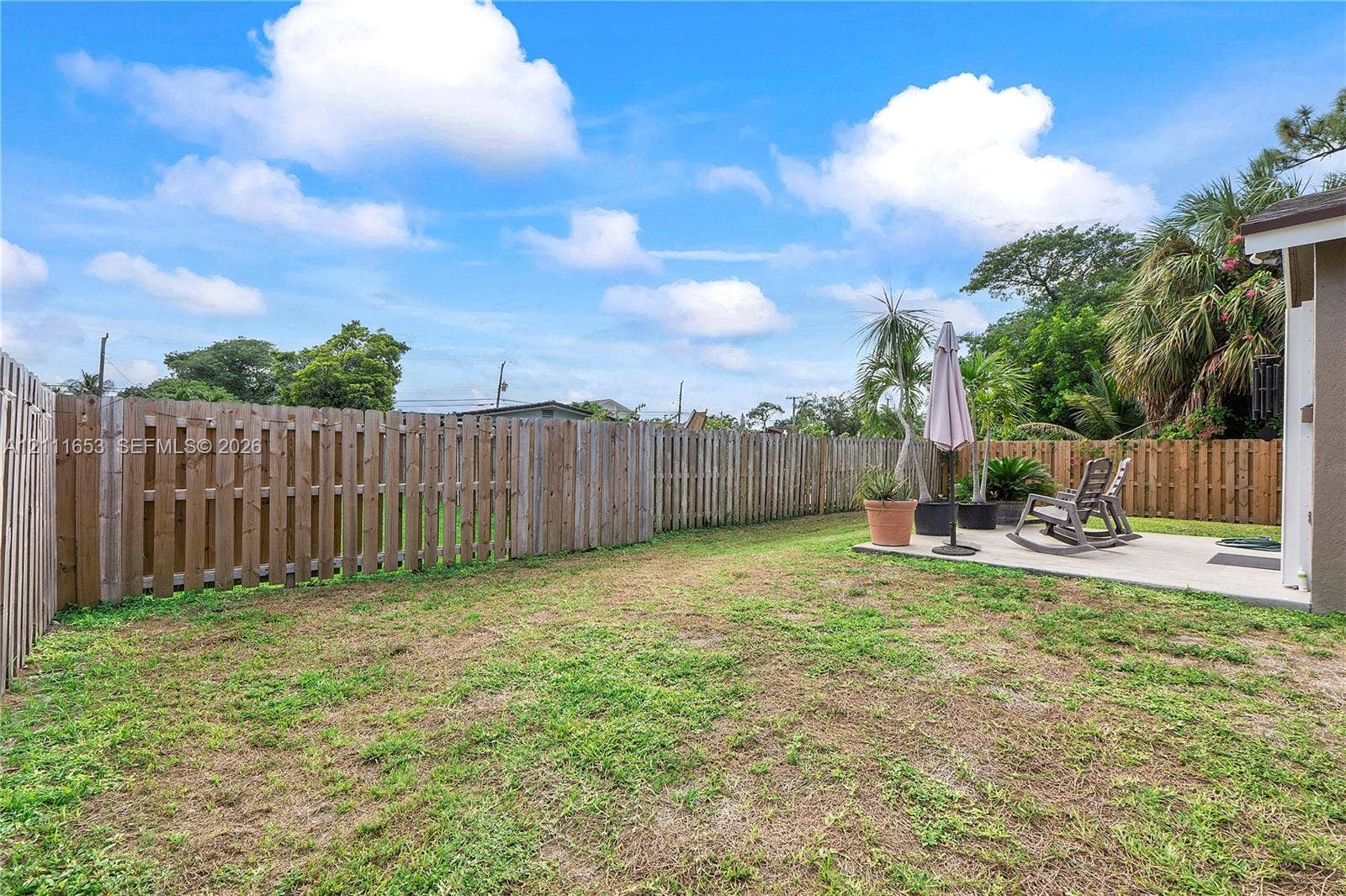 1042 NE 38th Street, Oakland Park, FL 33334 Fenced backyard featuring a concrete patio and open green space