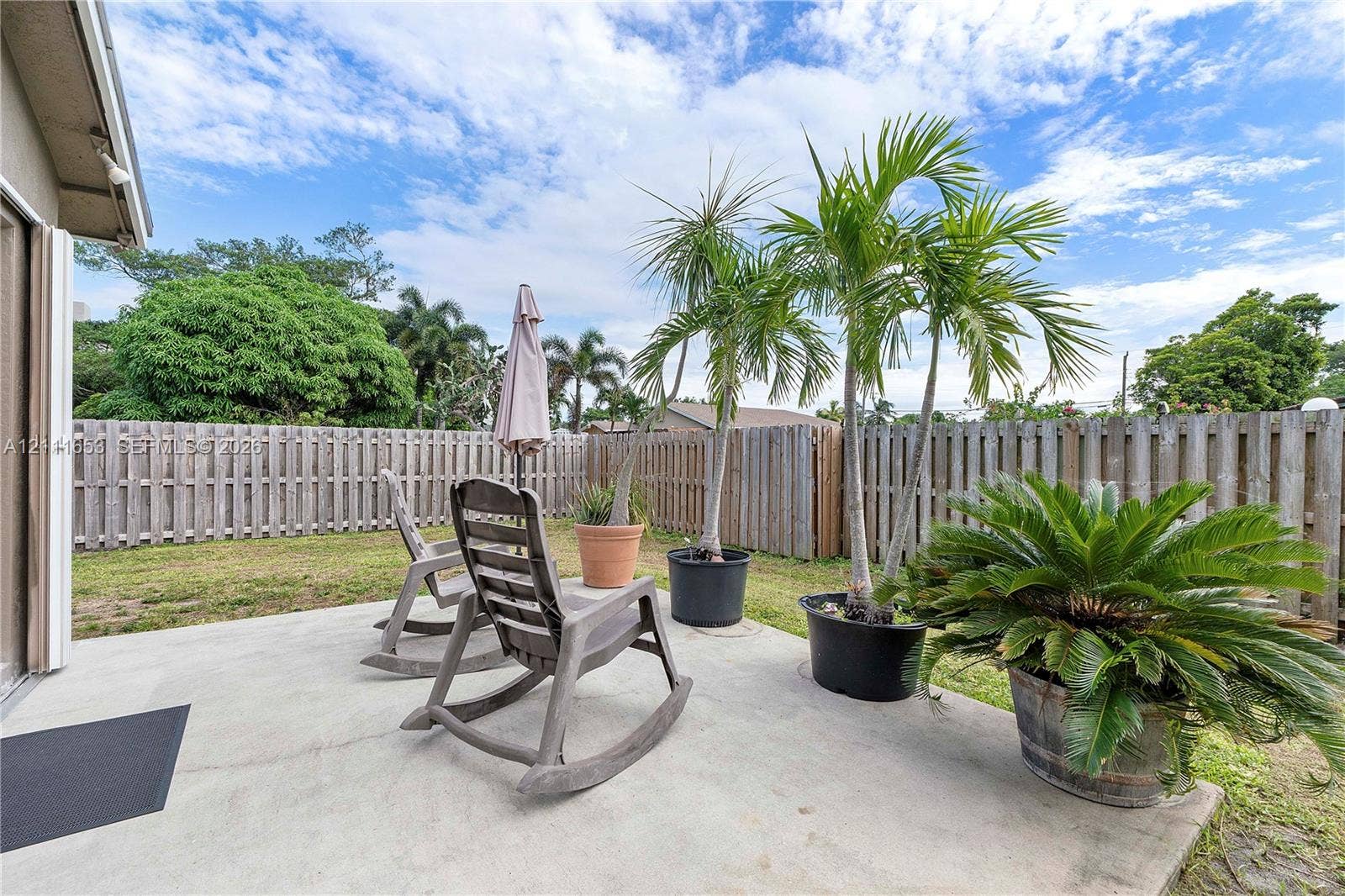 1042 NE 38th Street, Oakland Park, FL 33334 Concrete patio space enclosed by wood privacy fencing
