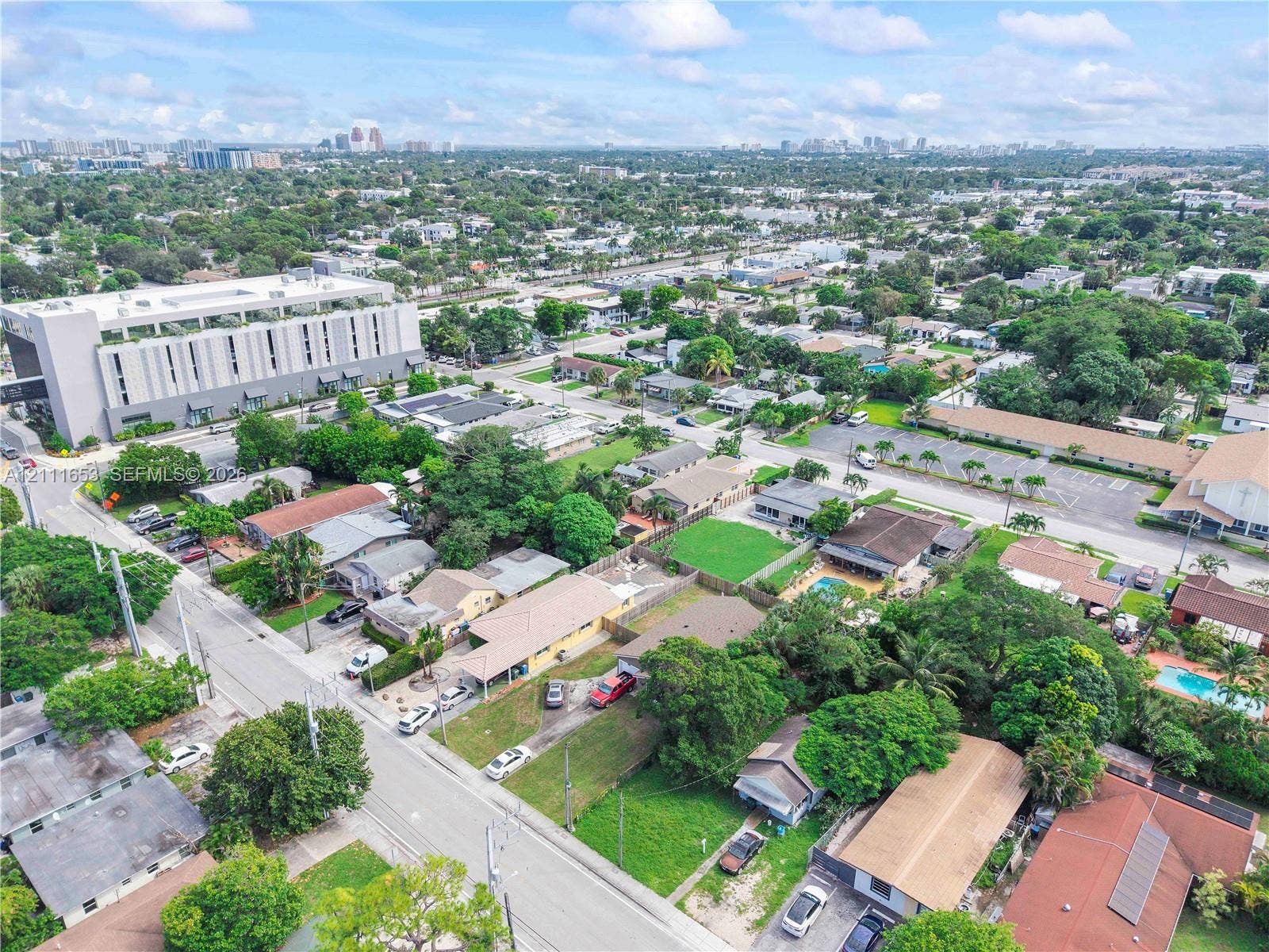 1042 NE 38th Street, Oakland Park, FL 33334 Aerial perspective featuring established residential surroundings with mature trees, expansive green lawns, and diverse roofline configurations