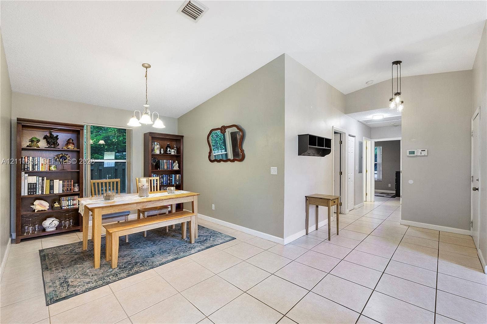 1042 NE 38th Street, Oakland Park, FL 33334 Formal Dining with vaulted ceilings, large-format tile flooring, and multi-light pendant fixtures