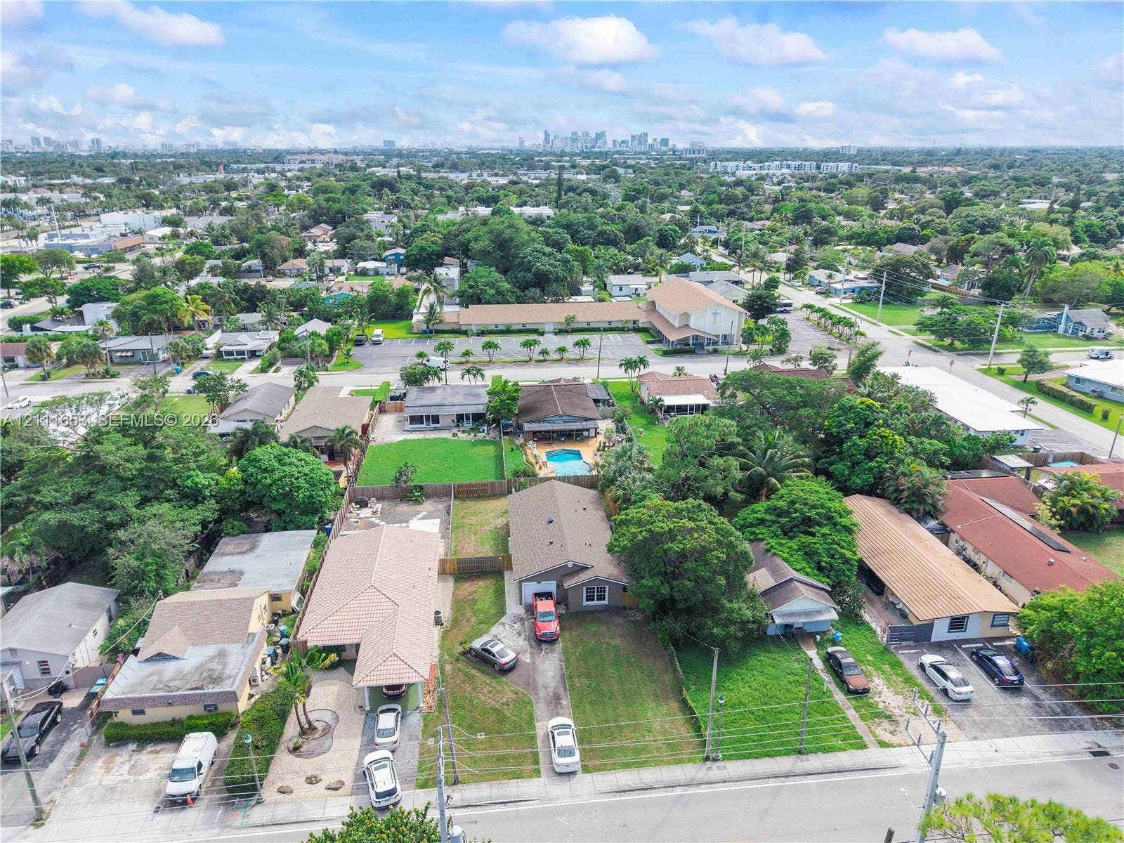 1042 NE 38th Street, Oakland Park, FL 33334 Aerial perspective featuring expansive residential lots with mature trees, established landscaping, and paved driveways