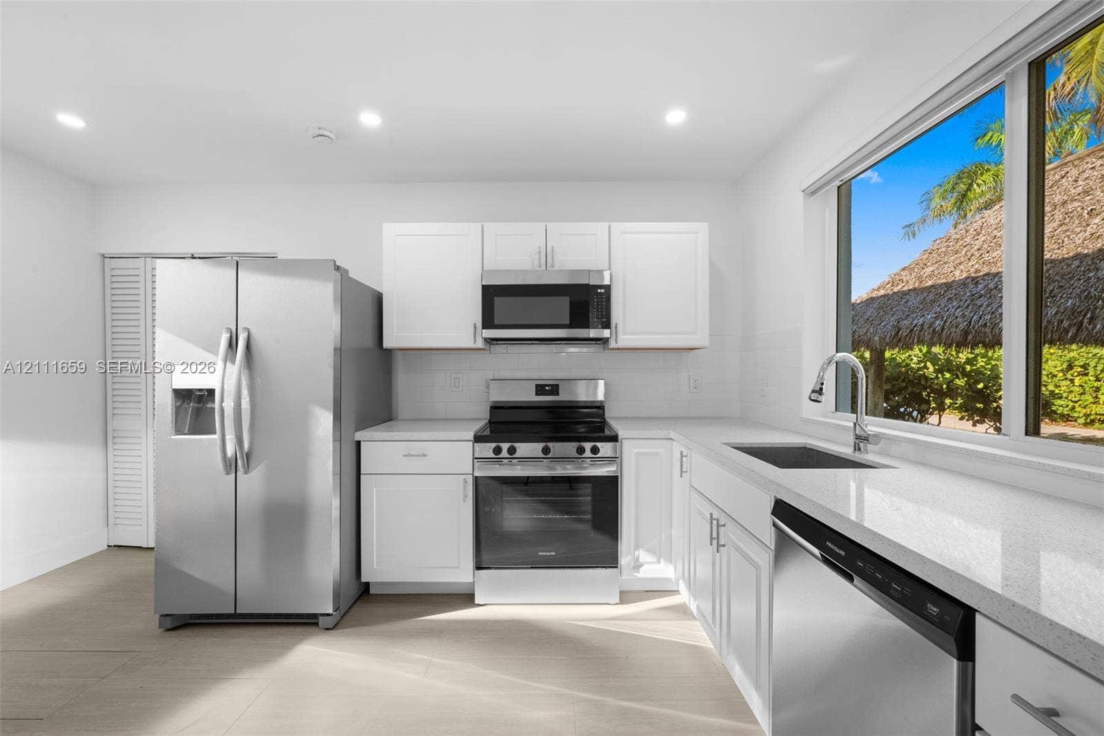 338 Taylor Street, #2, Hollywood, Hollywood, FL 33019 Kitchen featuring white Shaker-style cabinetry, quartz countertops, stainless steel appliances, a single-basin undermount sink with a gooseneck faucet, and tile flooring