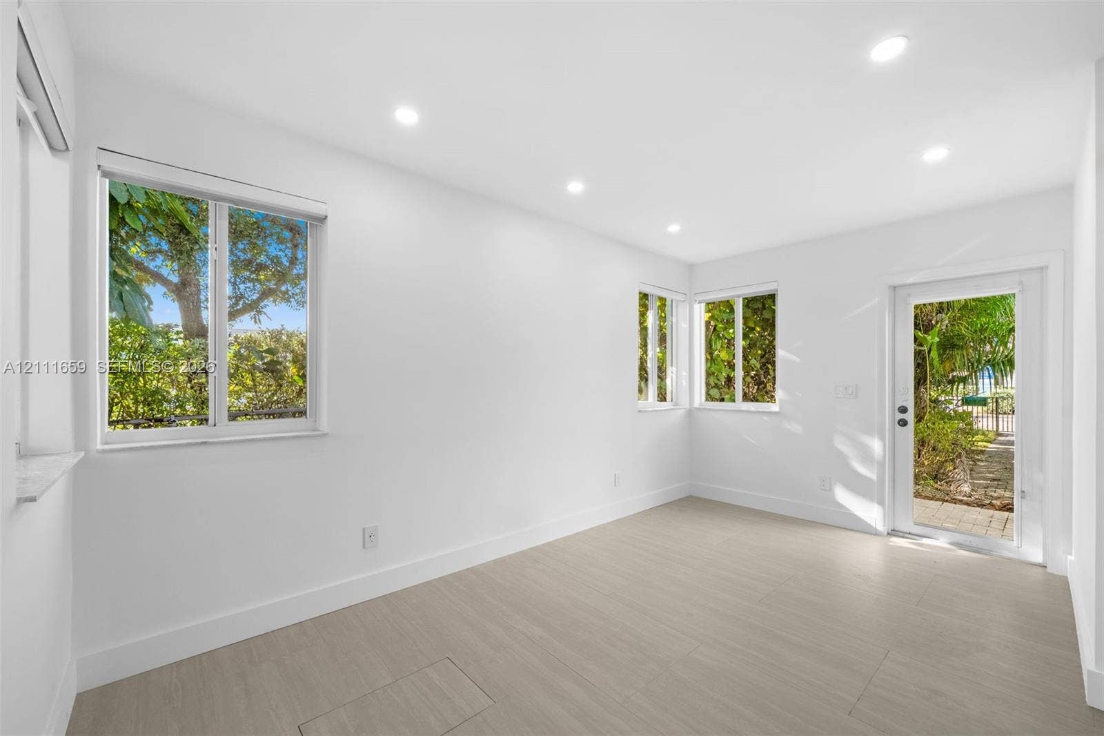 338 Taylor Street, #2, Hollywood, Hollywood, FL 33019 Interior space featuring wood-finish flooring, recessed lighting, white walls, large windows, and a glass-paneled exterior door