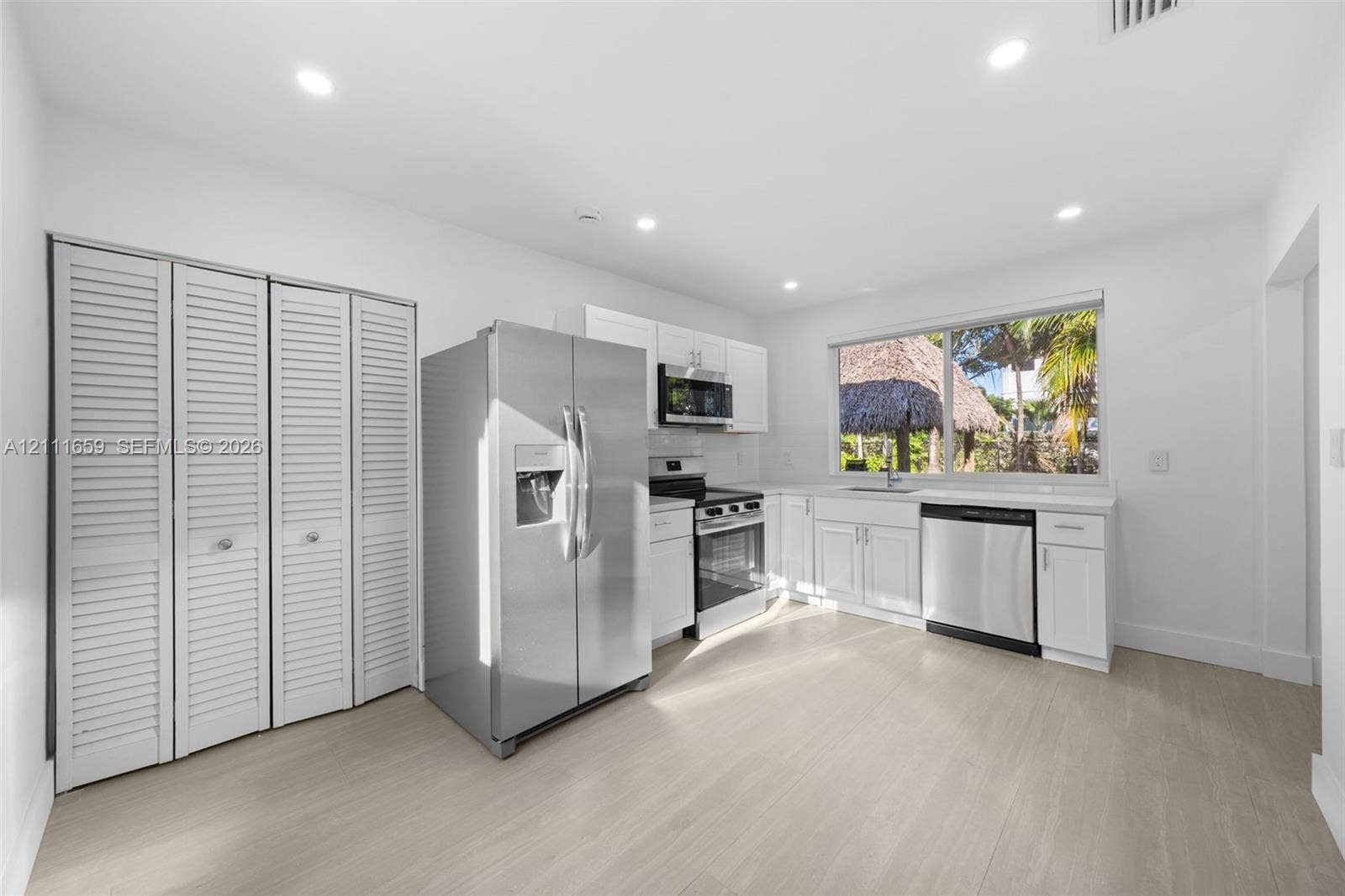 338 Taylor Street, #2, Hollywood, Hollywood, FL 33019 Kitchen featuring white cabinetry, stainless steel appliances, wood-finish flooring, recessed lighting, and louvered closet doors