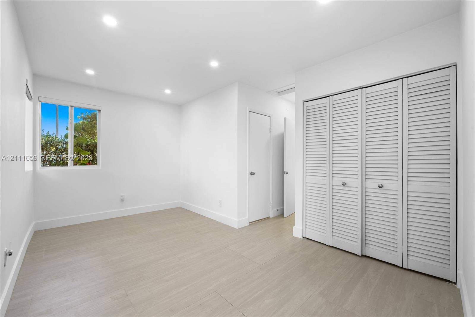 338 Taylor Street, #2, Hollywood, Hollywood, FL 33019 Interior room featuring wood-finish flooring, recessed lighting, white louvered-style bi-fold closet doors, and a single-pane window