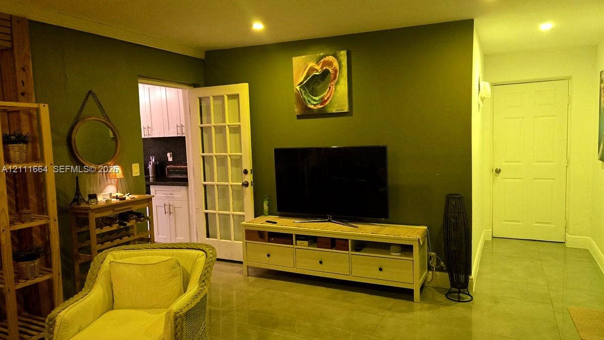 Interior room featuring polished tile flooring, recessed ceiling lighting, and a white six-panel door