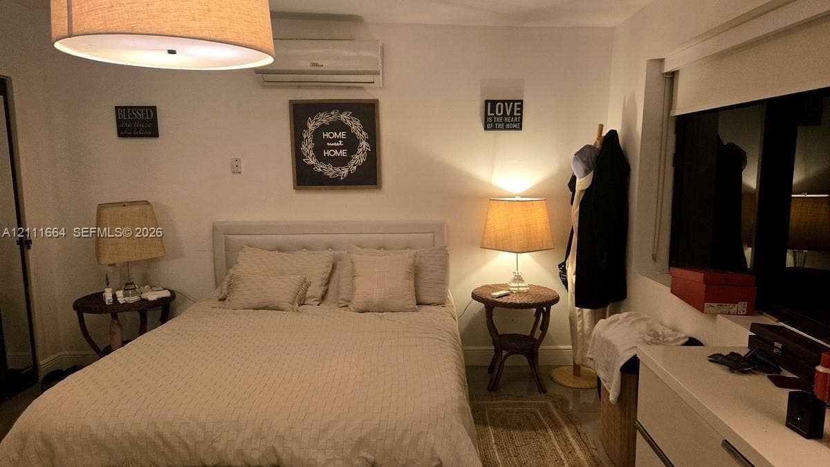 Wall-mounted ductless air conditioning unit, large drum pendant lighting fixture, and window with built-in shade